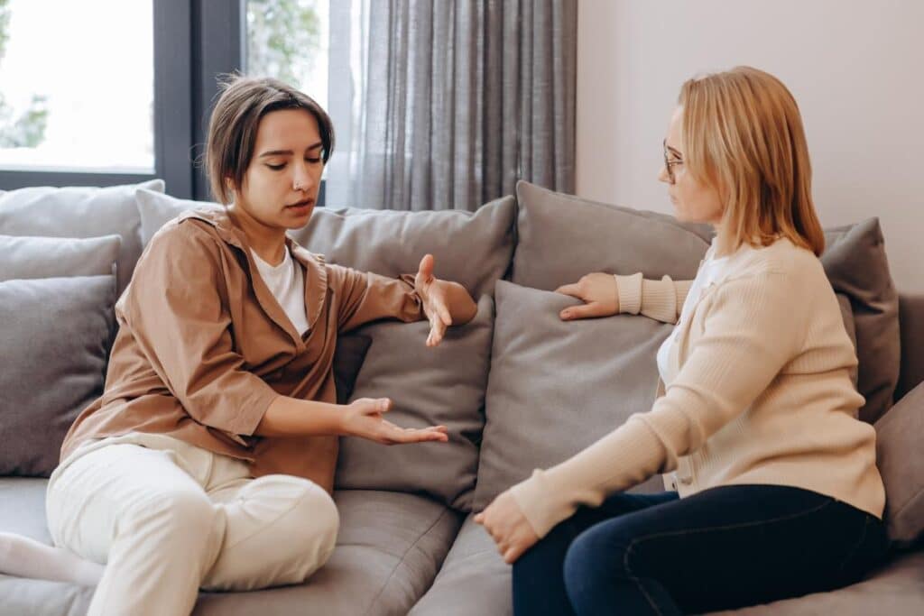 Two people on couch, talking about the dangers of inhalant abuse