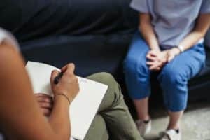 a person takes notes during a conversation possibly about 12 steps of narcotics anonymous