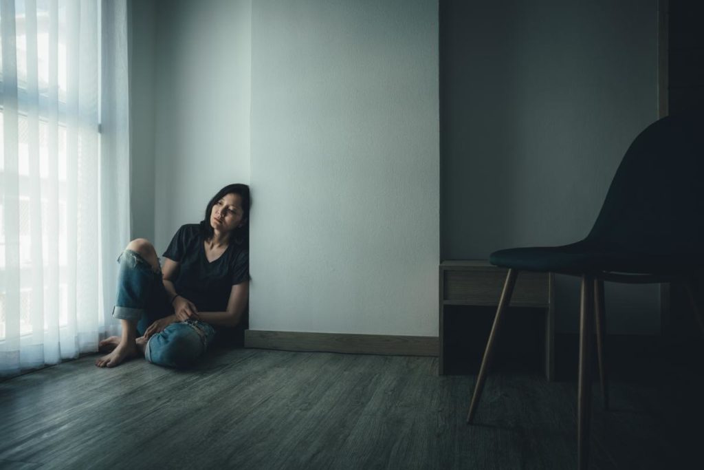 someone struggling with barbiturates abuse sits on the floor in a dark room