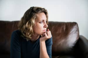 a person on a couch looks out a window struggling with mirtazapine addiction