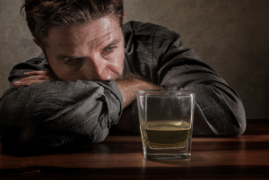 Man drinking alcohol while considering alcoholism facts