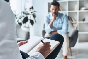 a person talks to a therapist holding a clipboard about phenibut powder