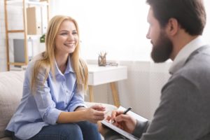 a woman talks to a man about inpatient vs outpatient rehab