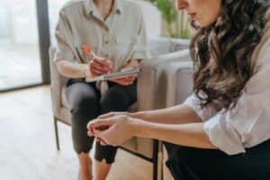 Hands of two people sitting next to each other at an ecstasy abuse rehab session