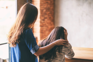 Person being comforted by someone seeing symptoms of meth use in a friend