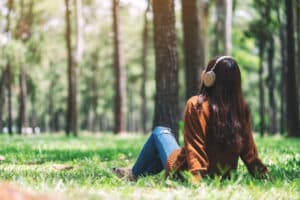 Person sitting on the ground outdoors and thinking about the principles of recovery