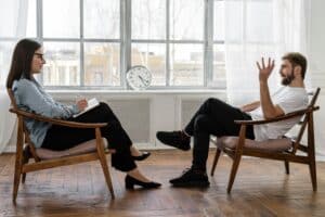 Two people in therapy discussing CBT, DBT, EMDR, and motivational interviewing