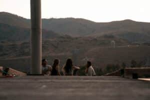 Back of four people on steps at rehab looking out at mountain view