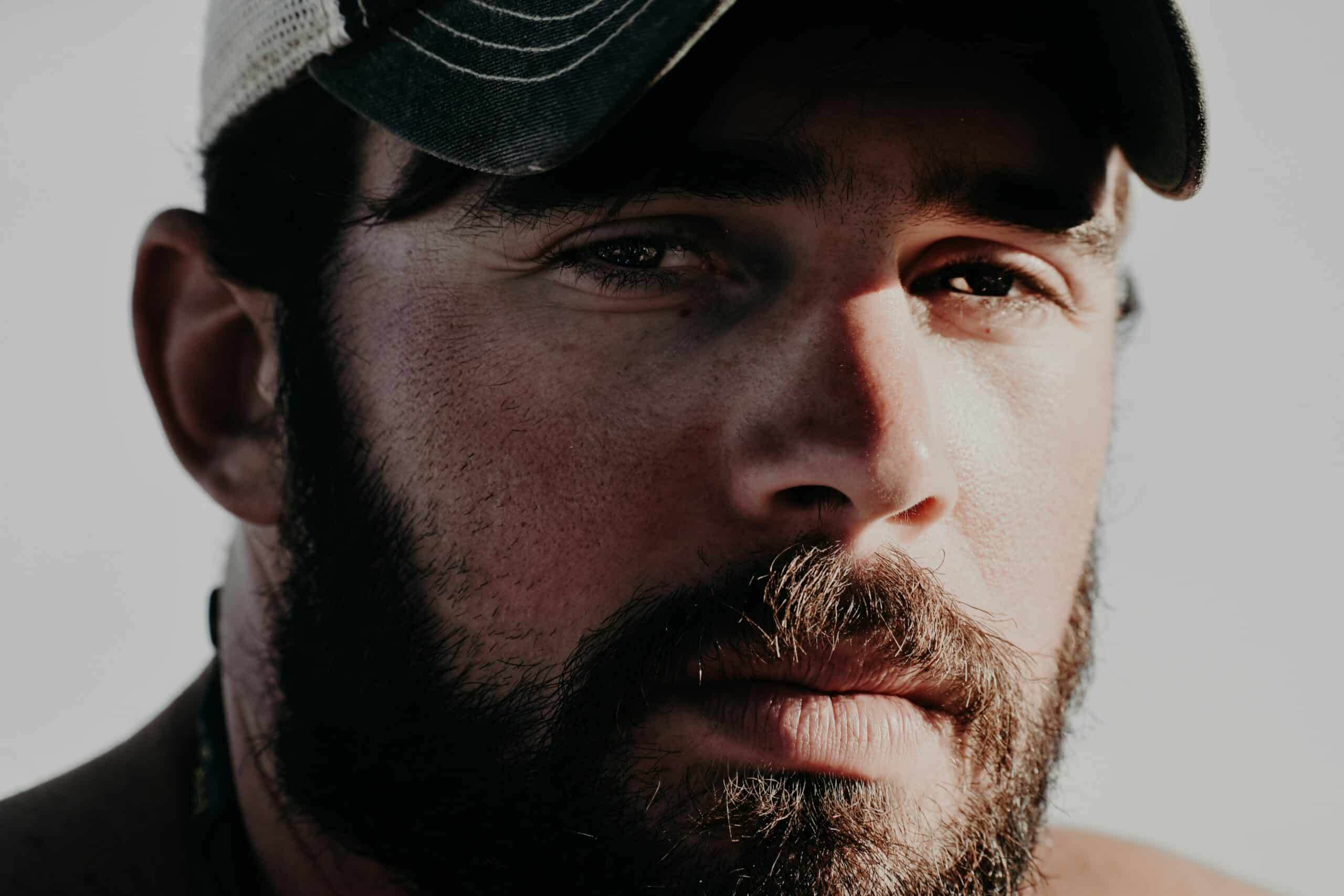 man with beard and mustache wearing black baseball cap