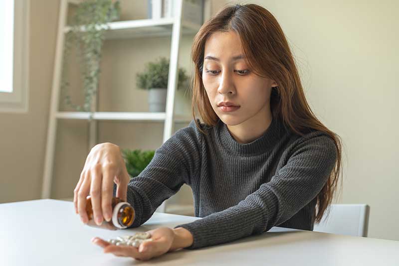 A woman with a pill bottle trying to determine if she's abusing Vyvanse or not