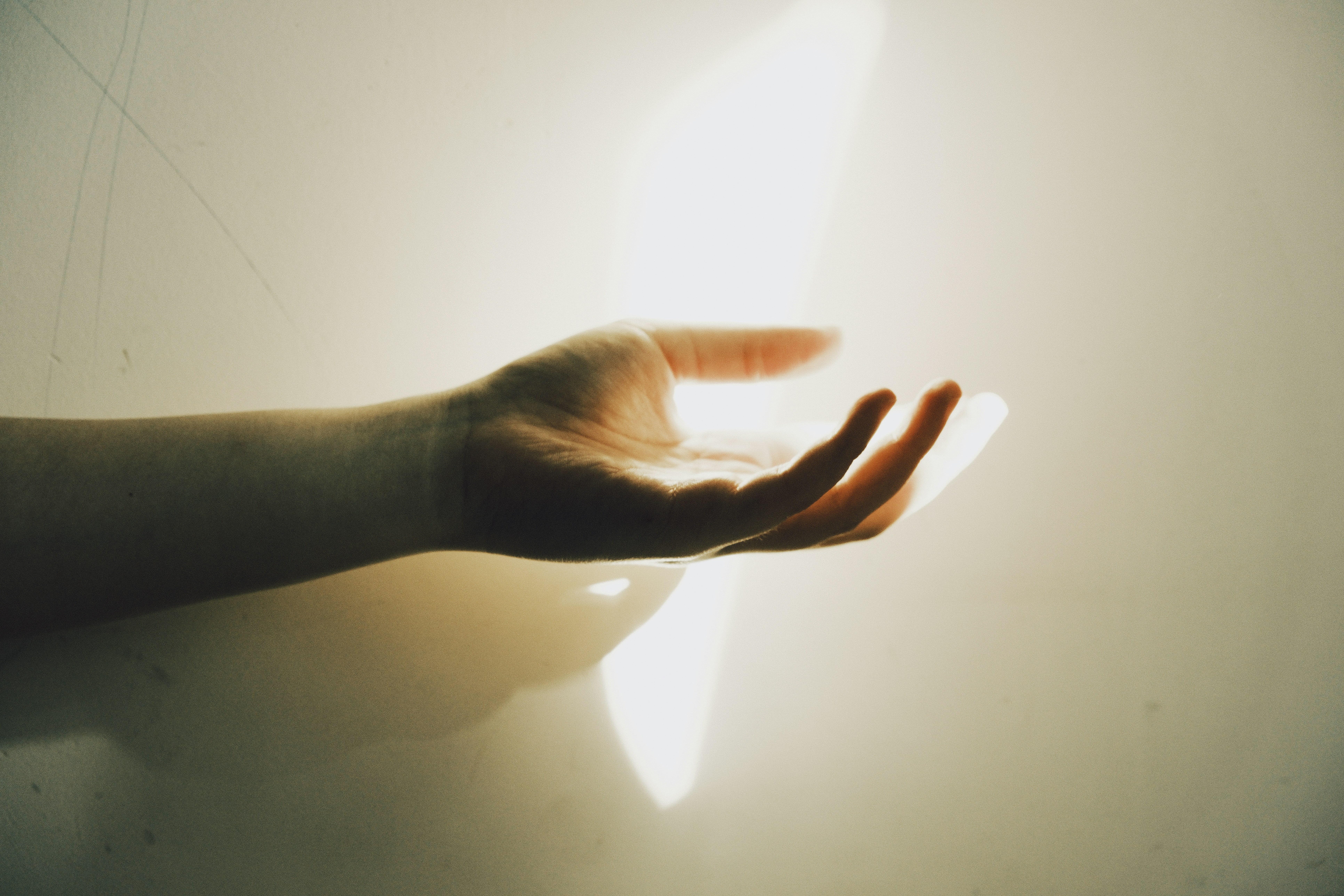 hand reaching out into beam of sunlight